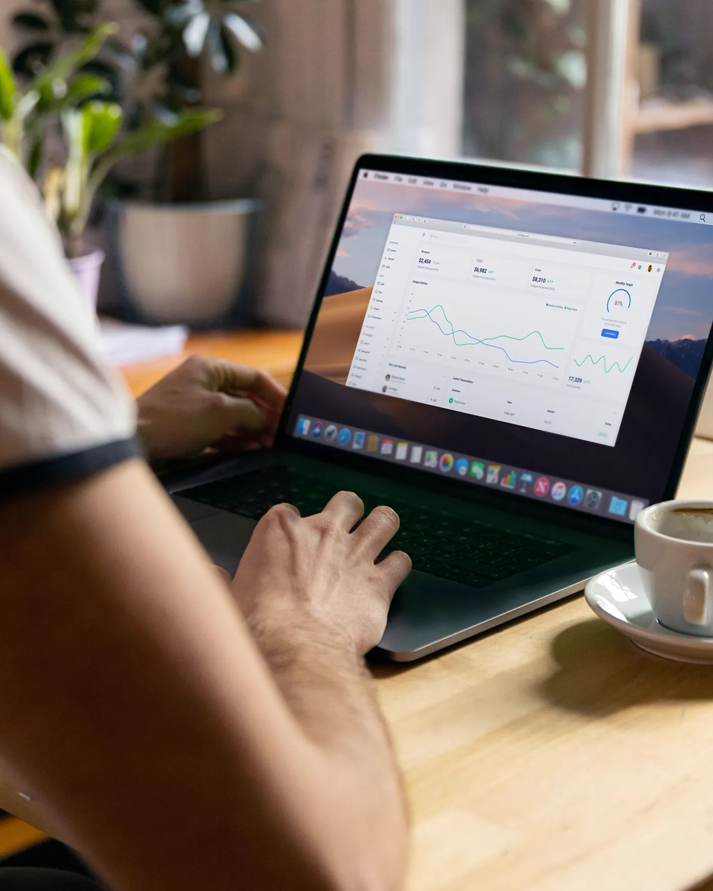 A person reviewing charts and figures on a laptop at a quiet desk.