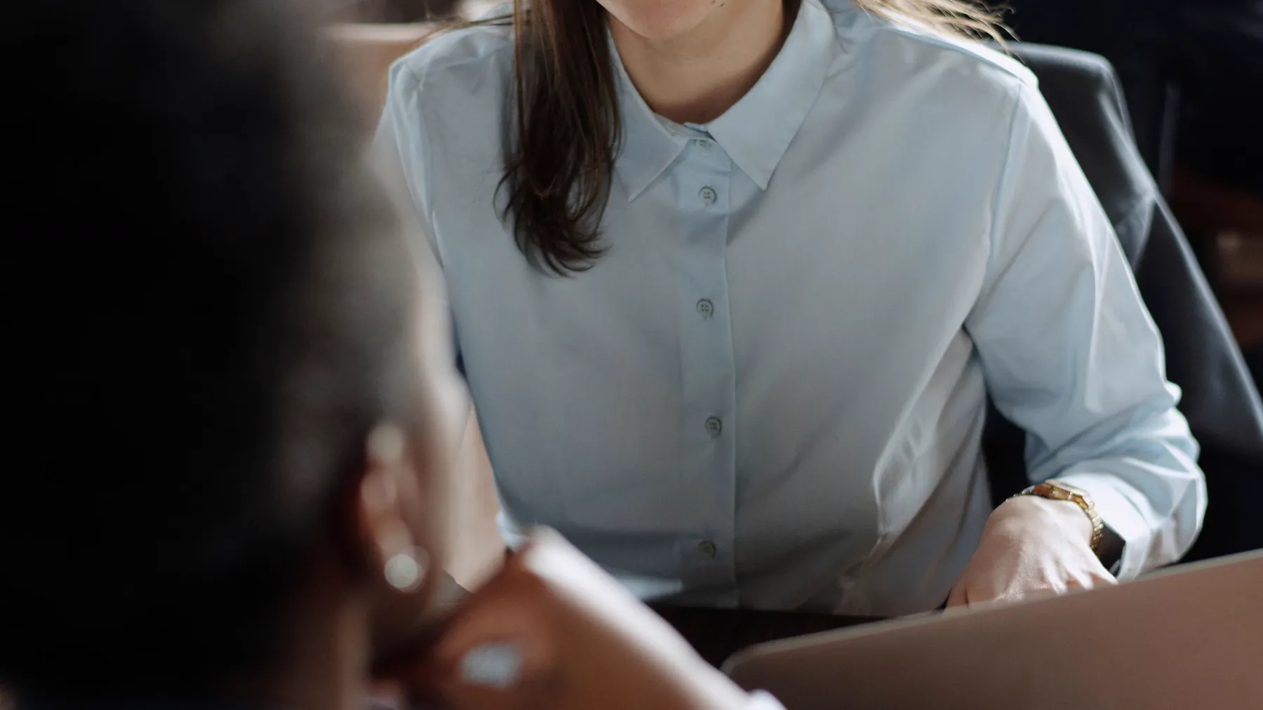 Two people in a focused conversation across a café table.